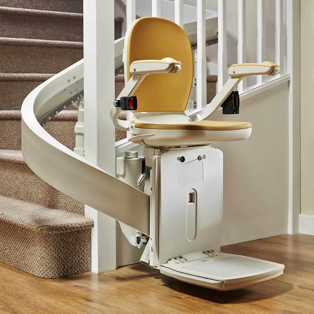 Curved stairlift fitted at the bottom of a staircase in a home